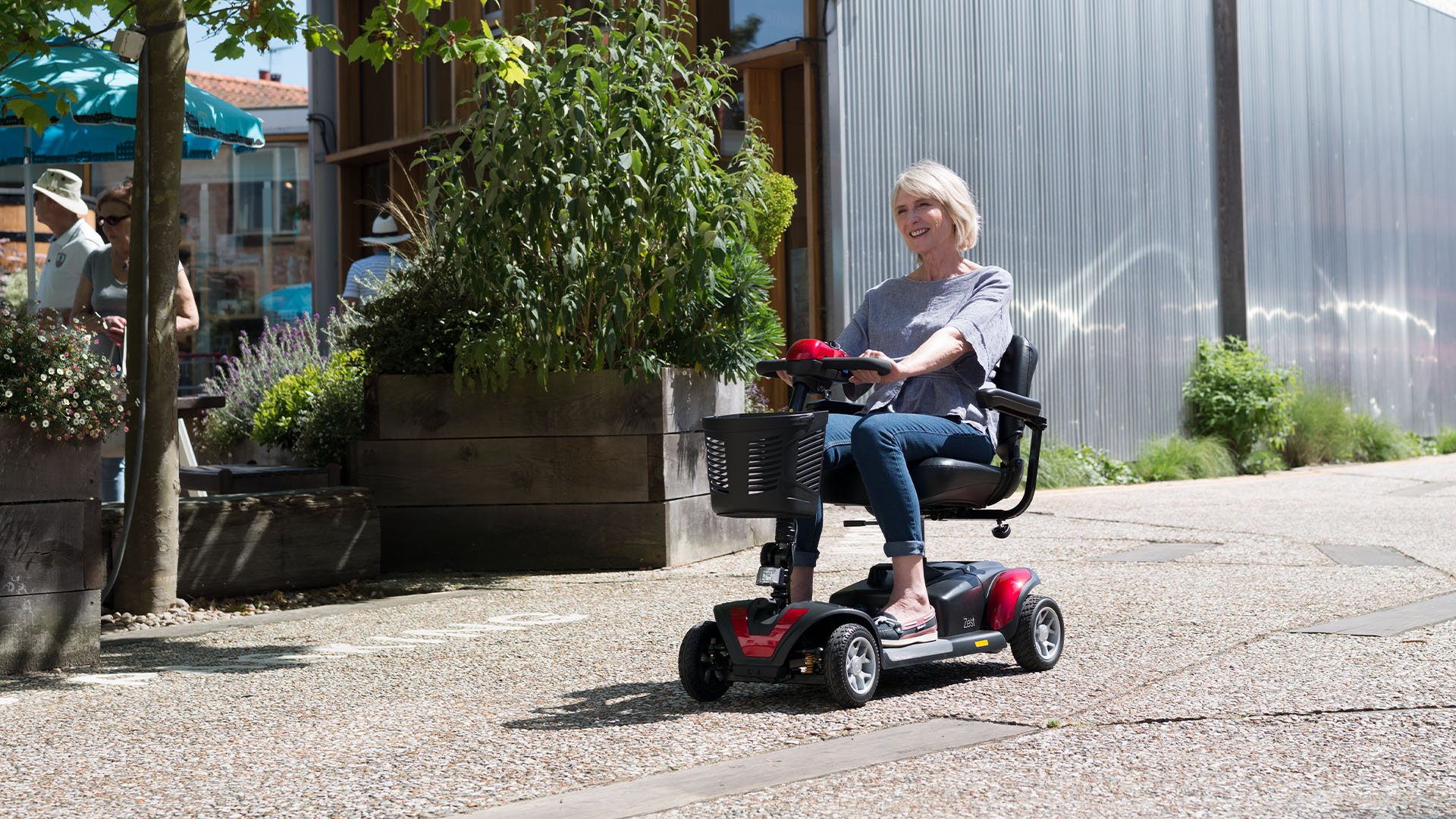 A woman riding a Zest lightweight mobility scooter