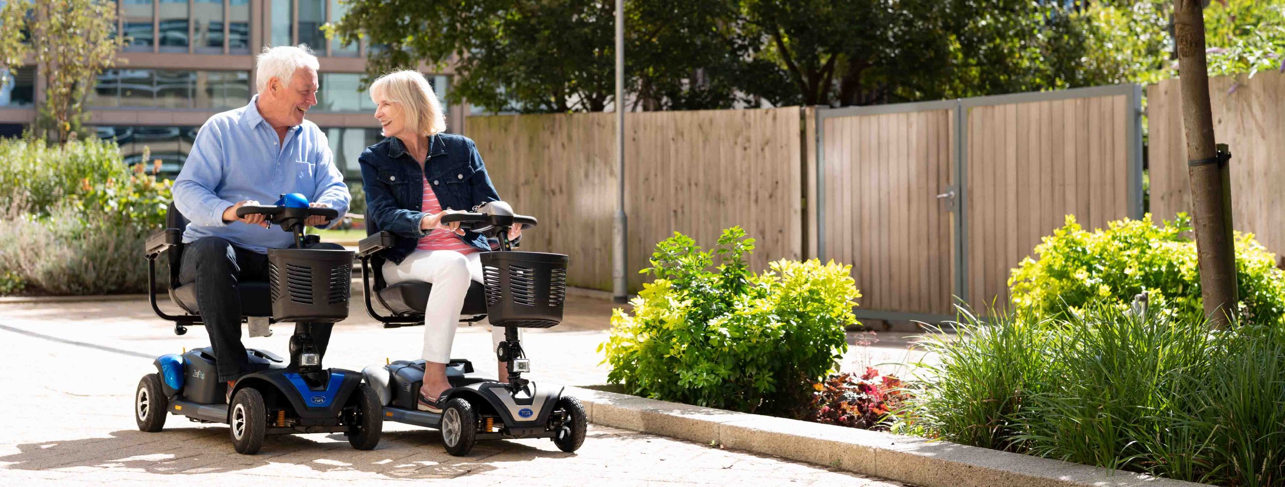 A man and woman next to each other on mobility scooters