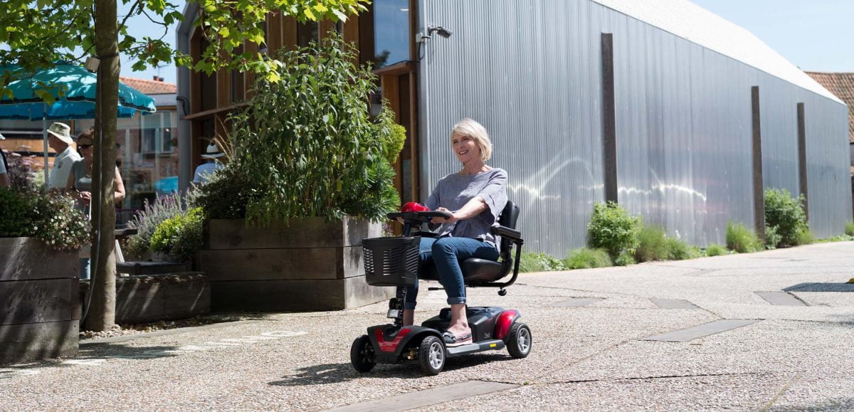 A lady using a TGA Zest lightweight mobility scooter